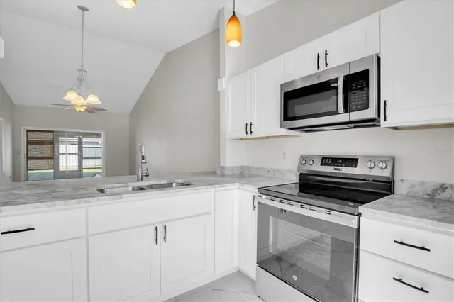 a kitchen with cabinets stainless steel appliances and a sink