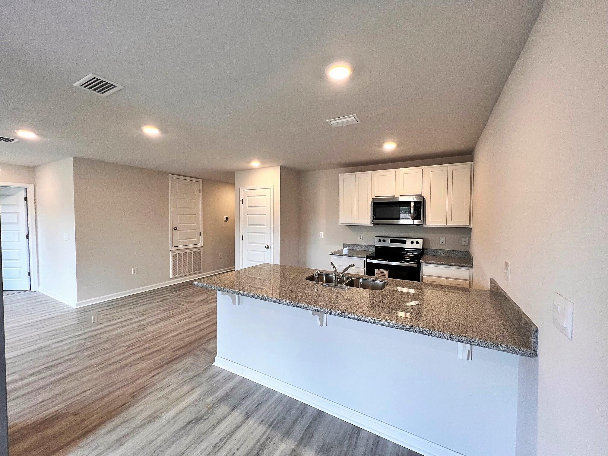 3100 Van Day Way Crestview, FL 32539 - Photo 3 of 16 a large kitchen with stainless steel appliances a large counter top and a stove top oven