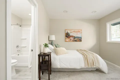 a bedroom with a bed and a painting on the wall