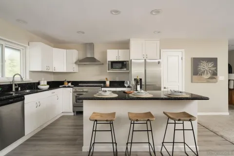 a kitchen with stainless steel appliances kitchen island granite countertop a sink and cabinets