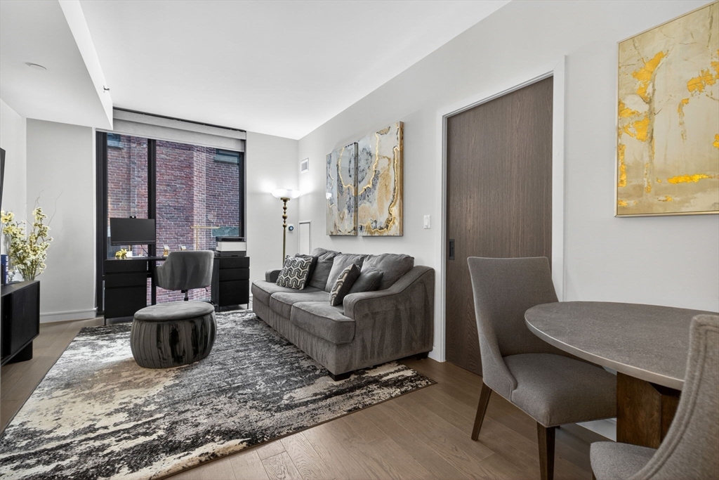 55 Lagrange Street, Unit 409 Boston, MA 02111 - Photo 3 of 29 a living room with furniture and wooden floor