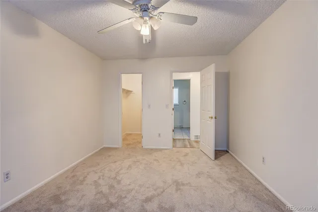 an empty room with closet and a chandelier fan