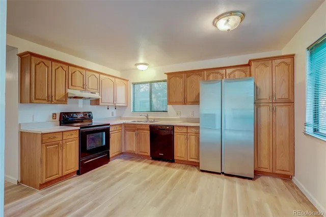 a kitchen with stainless steel appliances granite countertop a refrigerator and a stove top oven
