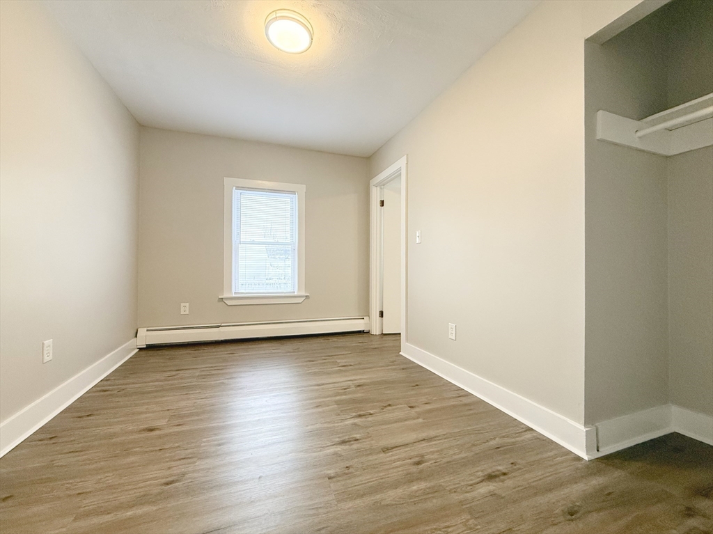 25 Kinsley Street, Unit I Nashua, NH 03060 - Photo 5 of 7 an empty room with wooden floor and windows