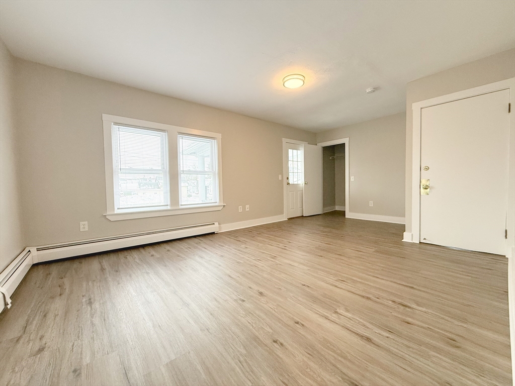 25 Kinsley Street, Unit I Nashua, NH 03060 - Photo 6 of 7 an empty room with wooden floor and windows