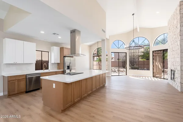 a large kitchen with granite countertop a stove oven and a large island with wooden floor