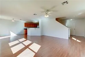 a view of a room with wooden floor and ceiling fan