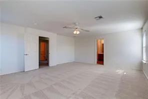 an empty room with an entryway and fan