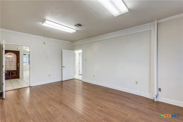 a view of an empty room with wooden floor