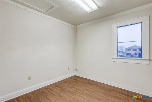 a view of a small space with wooden floor and a window