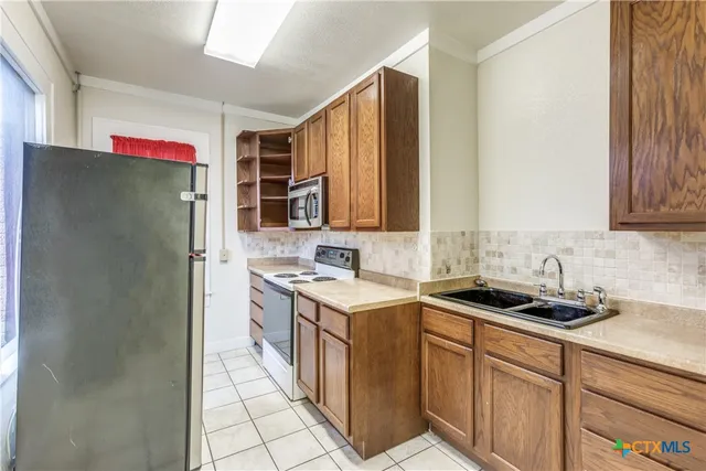 a kitchen with stainless steel appliances granite countertop a refrigerator and a stove