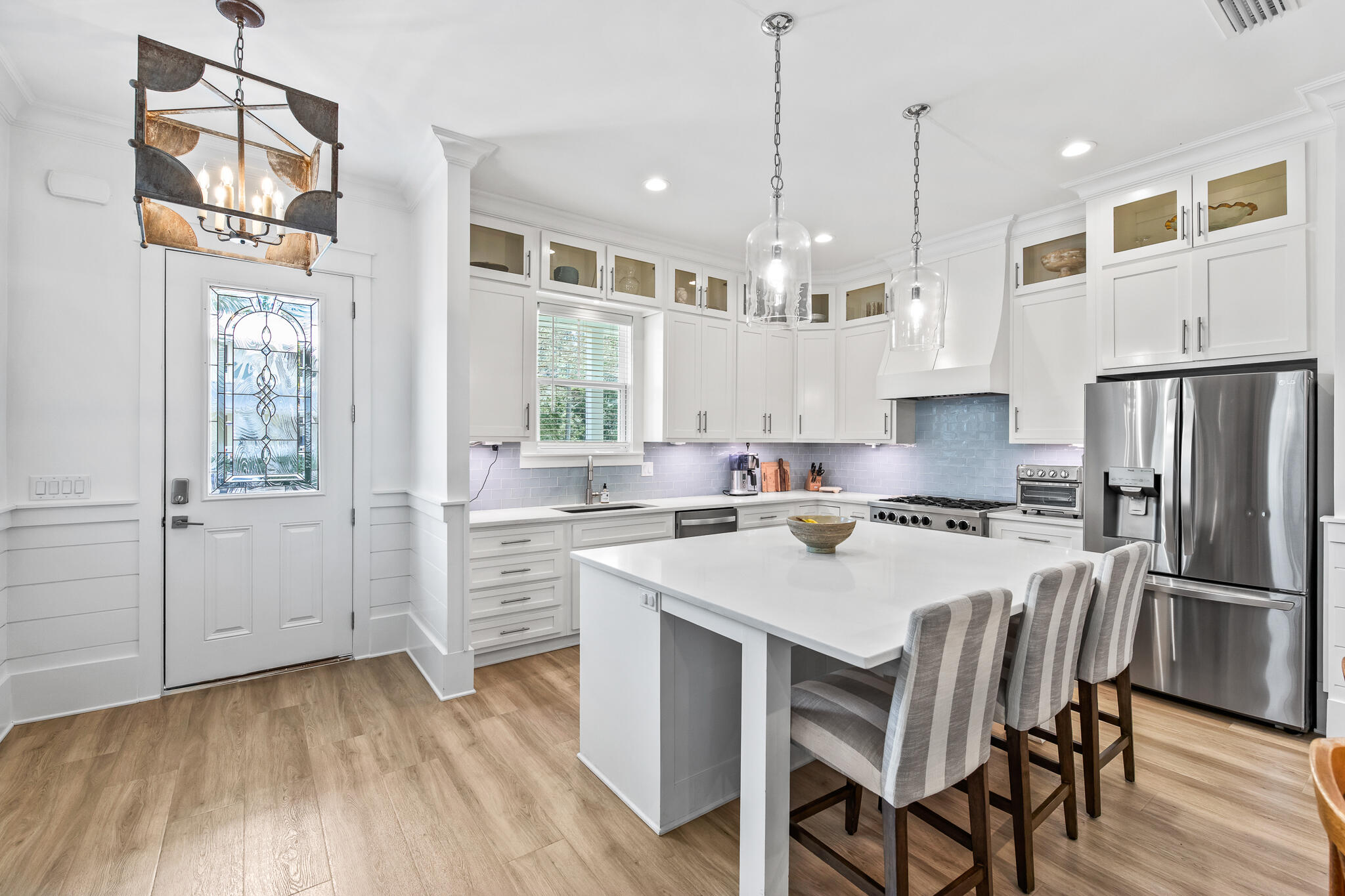 175 Greenbriar Lane Santa Rosa Beach, FL 32459 - Photo 3 of 77 a kitchen with a sink a stove a refrigerator and white cabinets with wooden floor