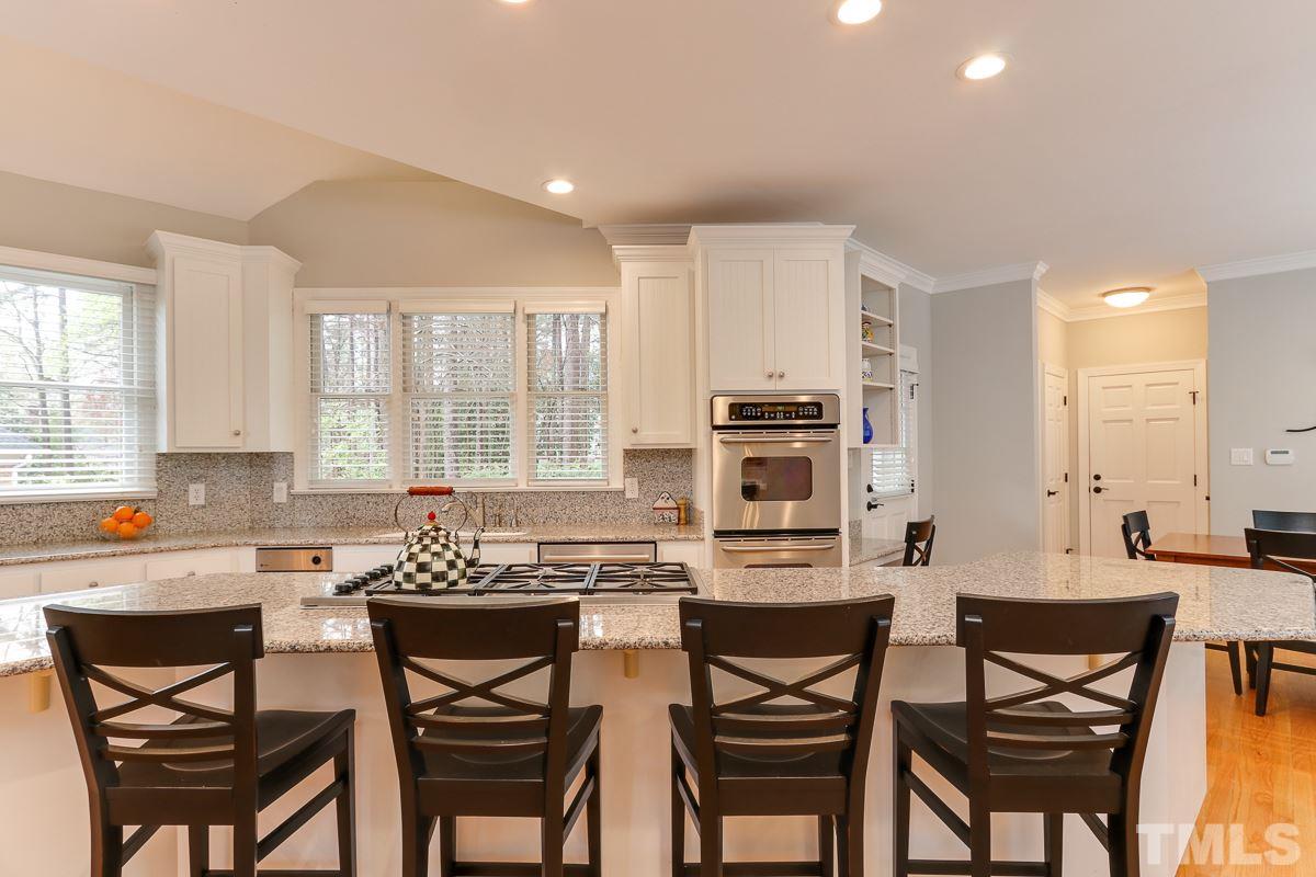 2001 Malvern Court Raleigh, NC 27615 - Photo 8 of 25 a kitchen with a dining table chairs and refrigerator