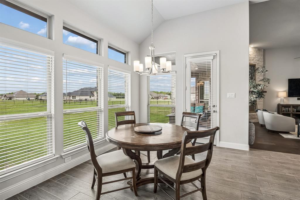 1581 Lynx Loop Forney, TX 75126 - Photo 16 of 38 Dining area with wood tiled floors, vaulted ceiling, and decorative lighting
