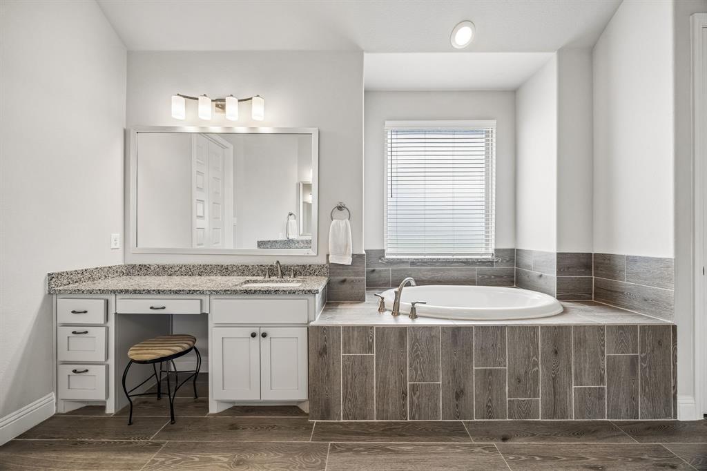 1581 Lynx Loop Forney, TX 75126 - Photo 24 of 38 Bathroom with vanity, a bath, and wood tiled floors