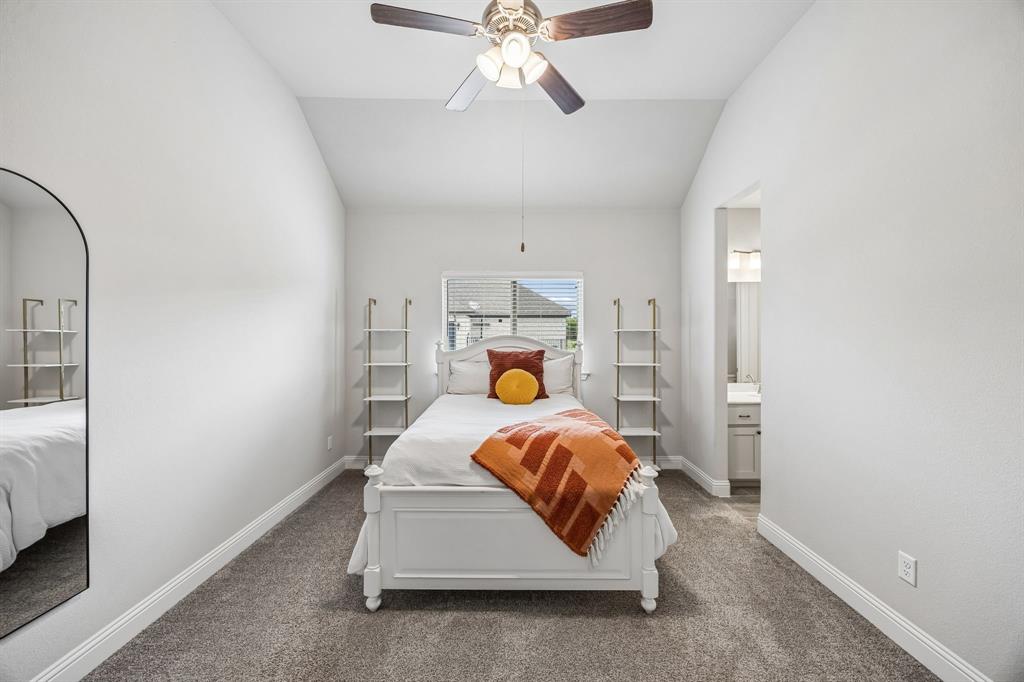 1581 Lynx Loop Forney, TX 75126 - Photo 25 of 38 Carpeted bedroom with lofted ceiling, a ceiling fan, and ensuite bath