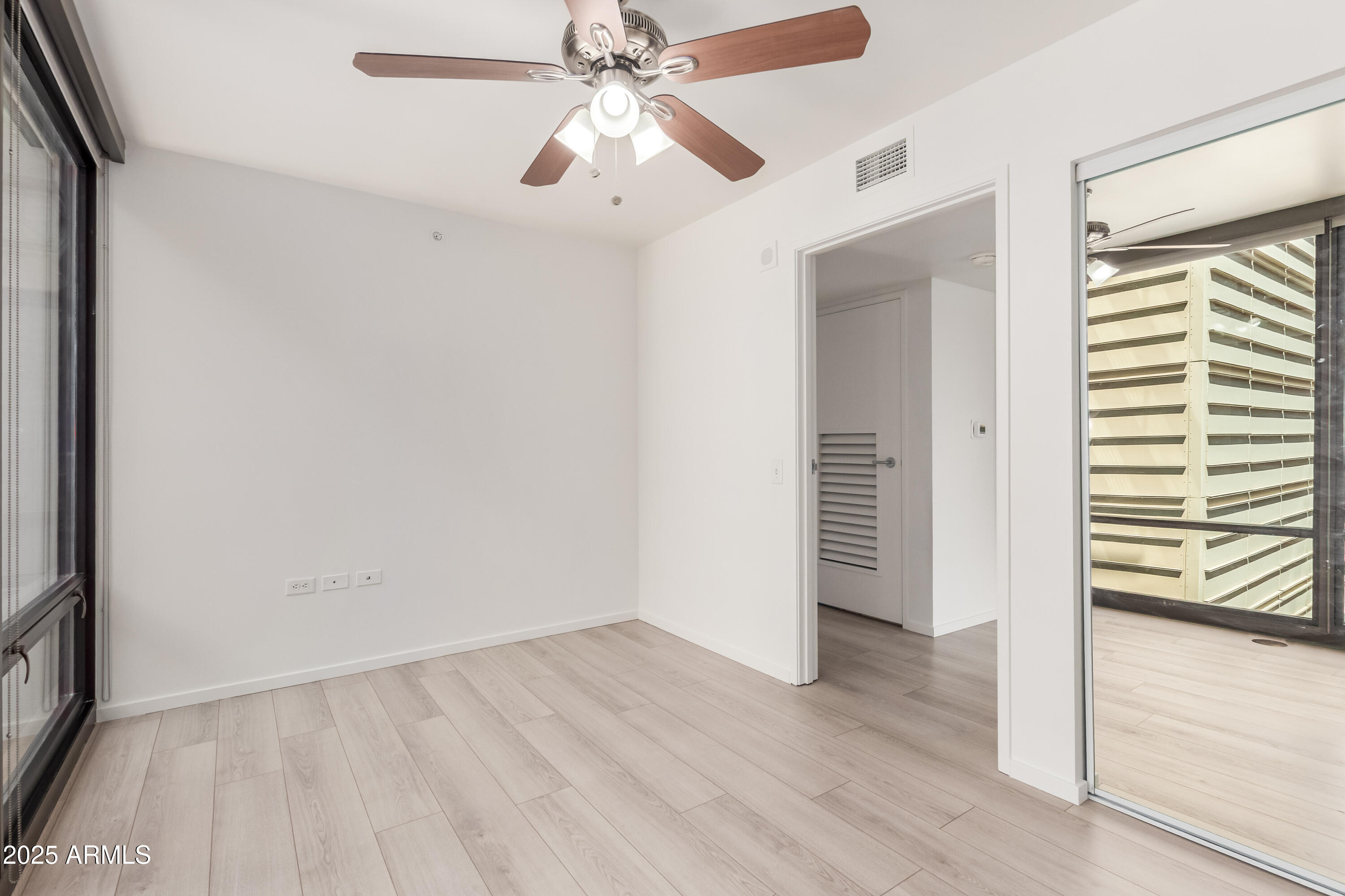 4808 North 24th Street, Unit 1005 Phoenix, AZ 85016 - Photo 18 of 34 an empty room with wooden floor chandelier fan and windows