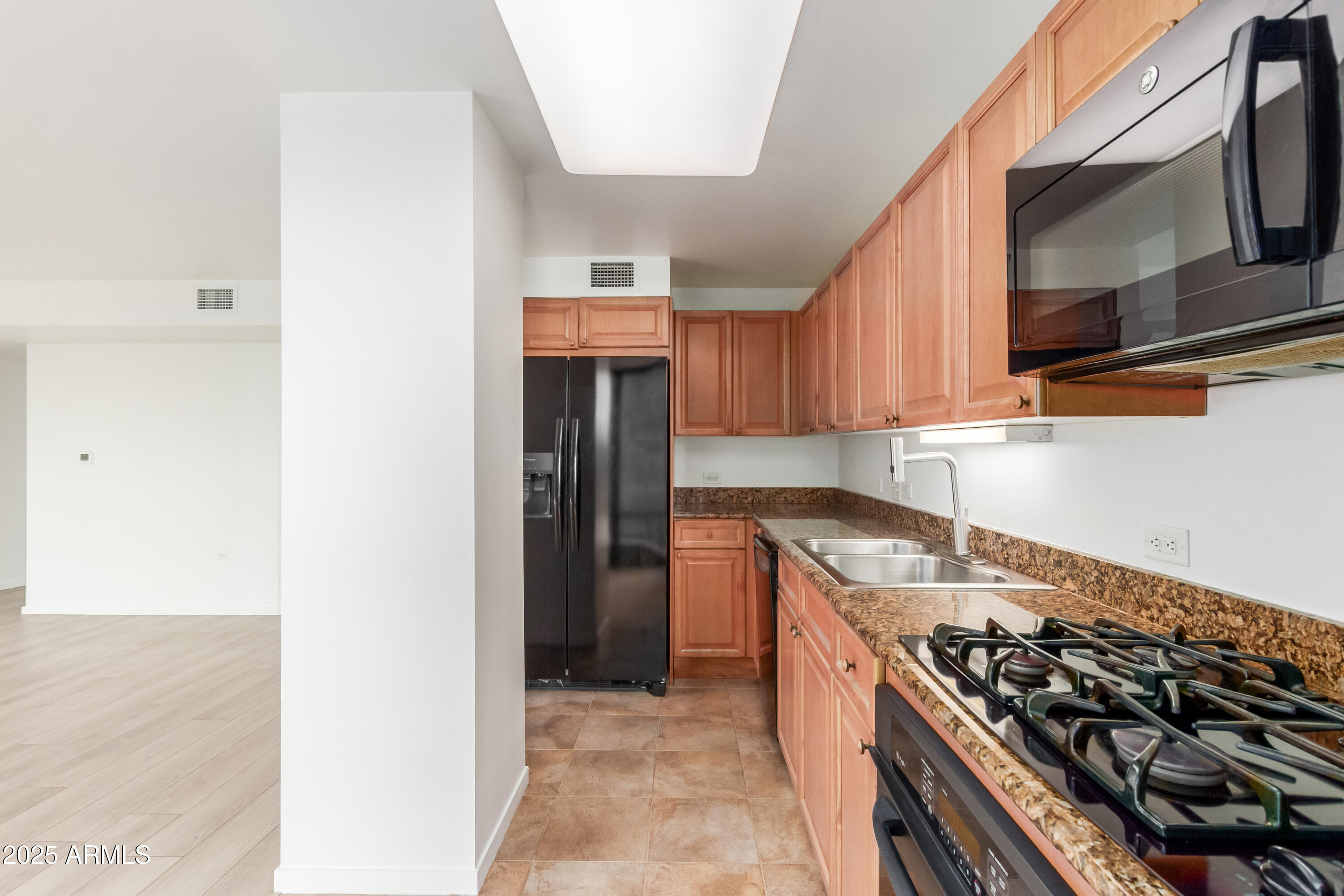 4808 North 24th Street, Unit 1005 Phoenix, AZ 85016 - Photo 7 of 34 a kitchen with stainless steel appliances granite countertop a stove and a microwave