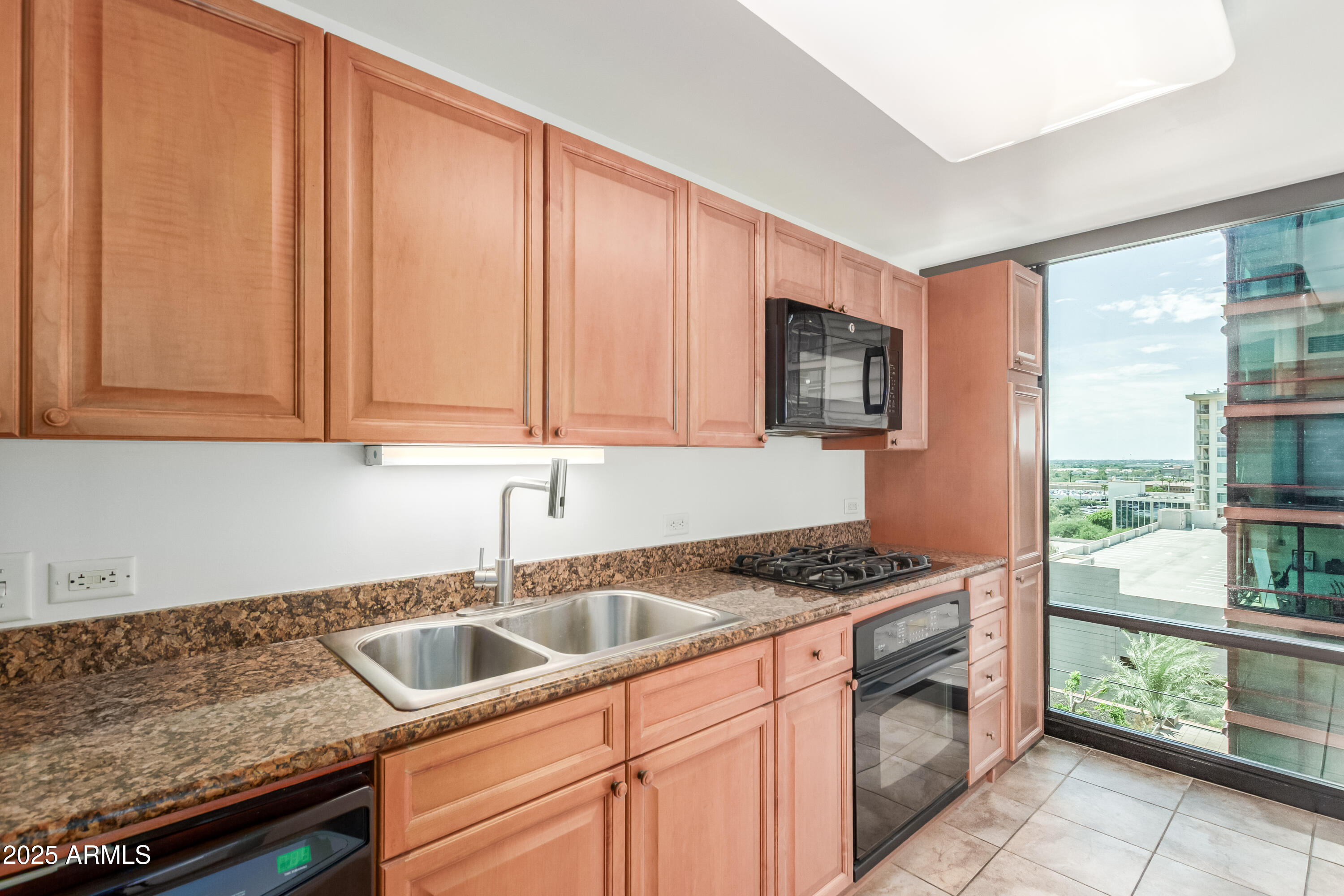 4808 North 24th Street, Unit 1005 Phoenix, AZ 85016 - Photo 9 of 34 a kitchen with granite countertop a sink stove and cabinets