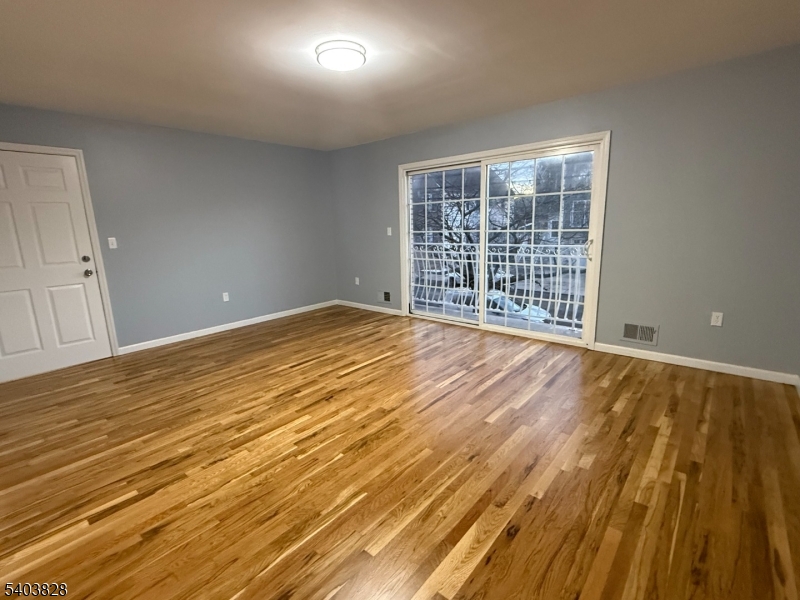 527 4th Avenue, Unit 1 Elizabeth, NJ 07202 - Photo 3 of 21 a view of an empty room with wooden floor and a window