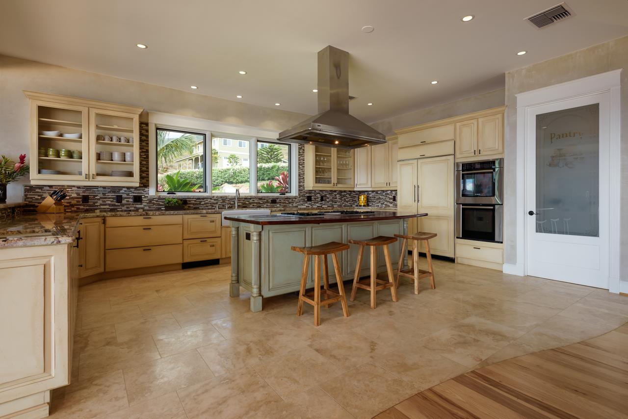 554 Punakea Loop Lahaina, HI 96761 - Photo 8 of 30 a kitchen with stainless steel appliances granite countertop a stove top oven a sink dishwasher a dining table and chairs with wooden floor