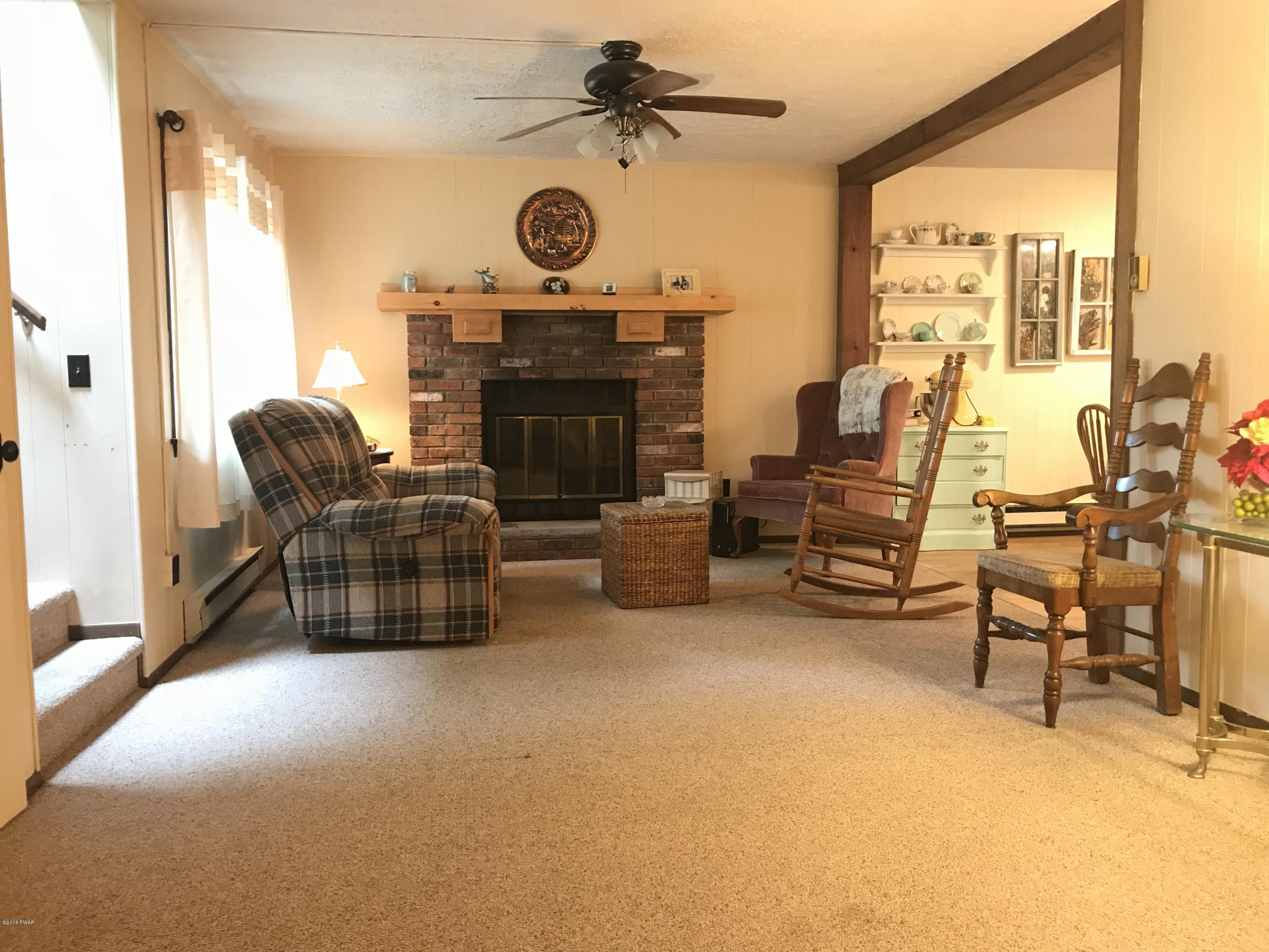 3187 Northgate Road Lake Ariel, PA 18436 - Photo 2 of 29 a living room with furniture a fireplace and a large window