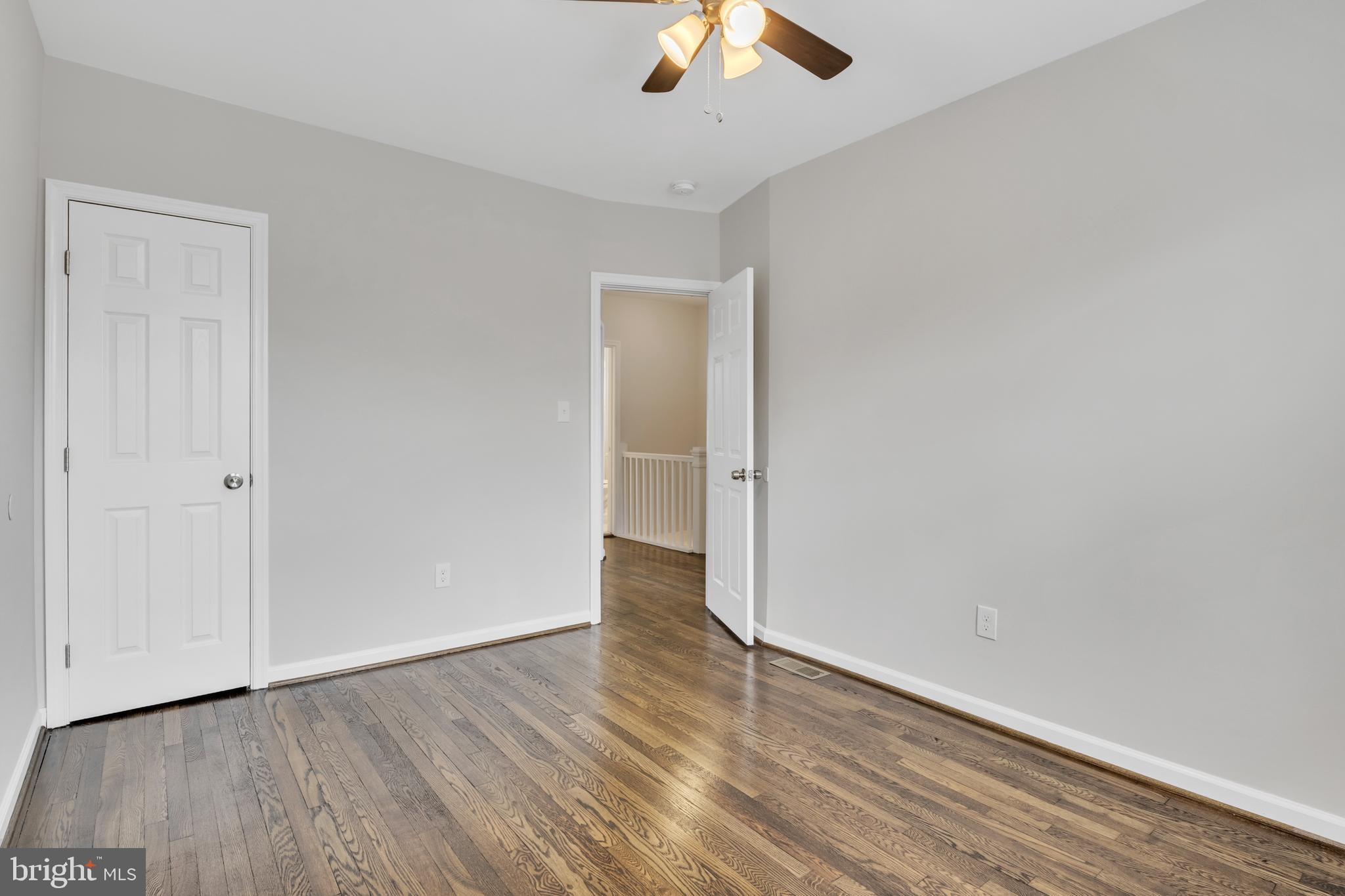 4437 Old York Road Baltimore, MD 21212 - Photo 11 of 15 an empty room with wooden floor cabinet and windows