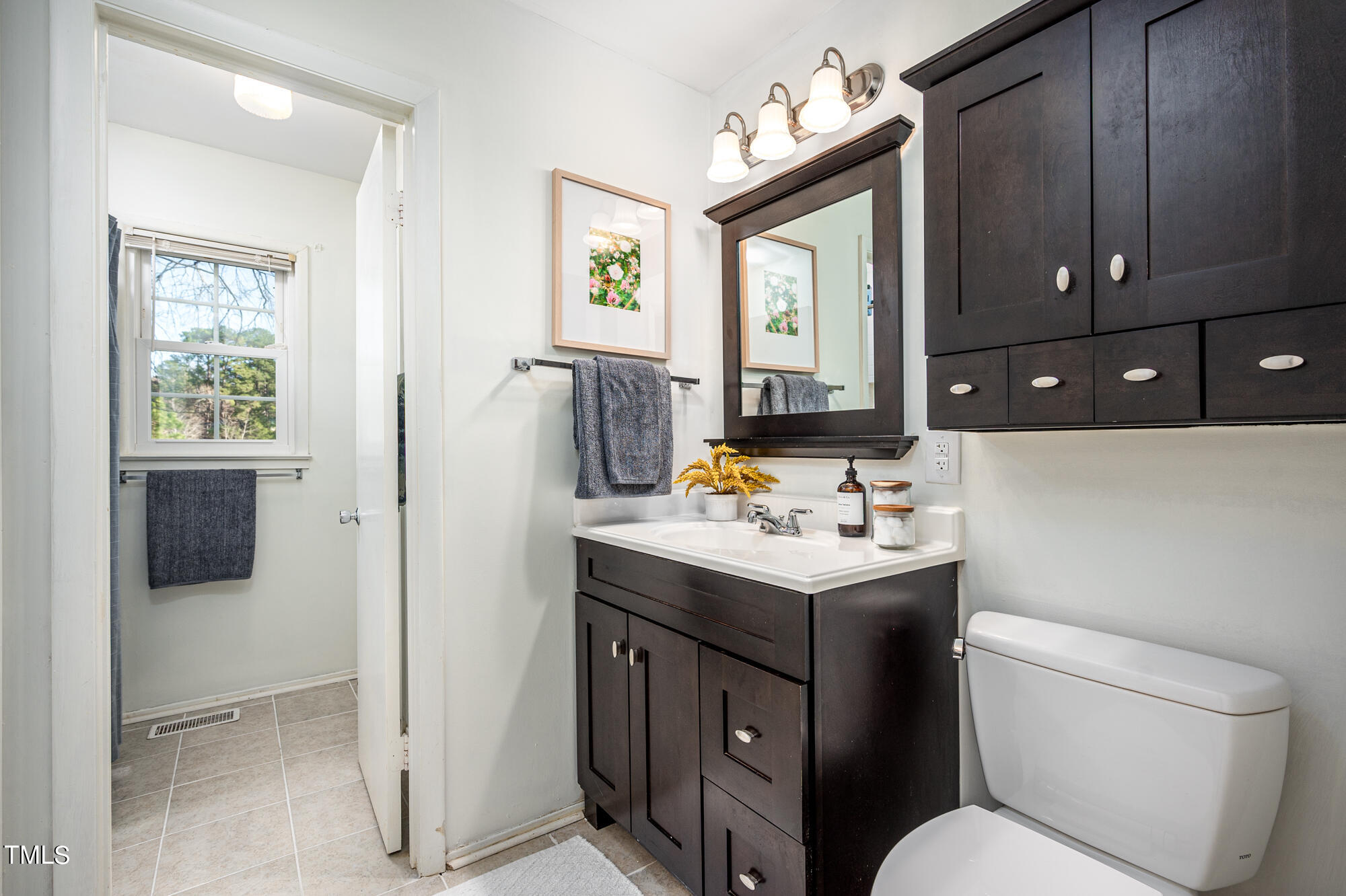 5215 Pelham Road Durham, NC 27713 - Photo 23 of 45 a bathroom with a toilet sink and mirror