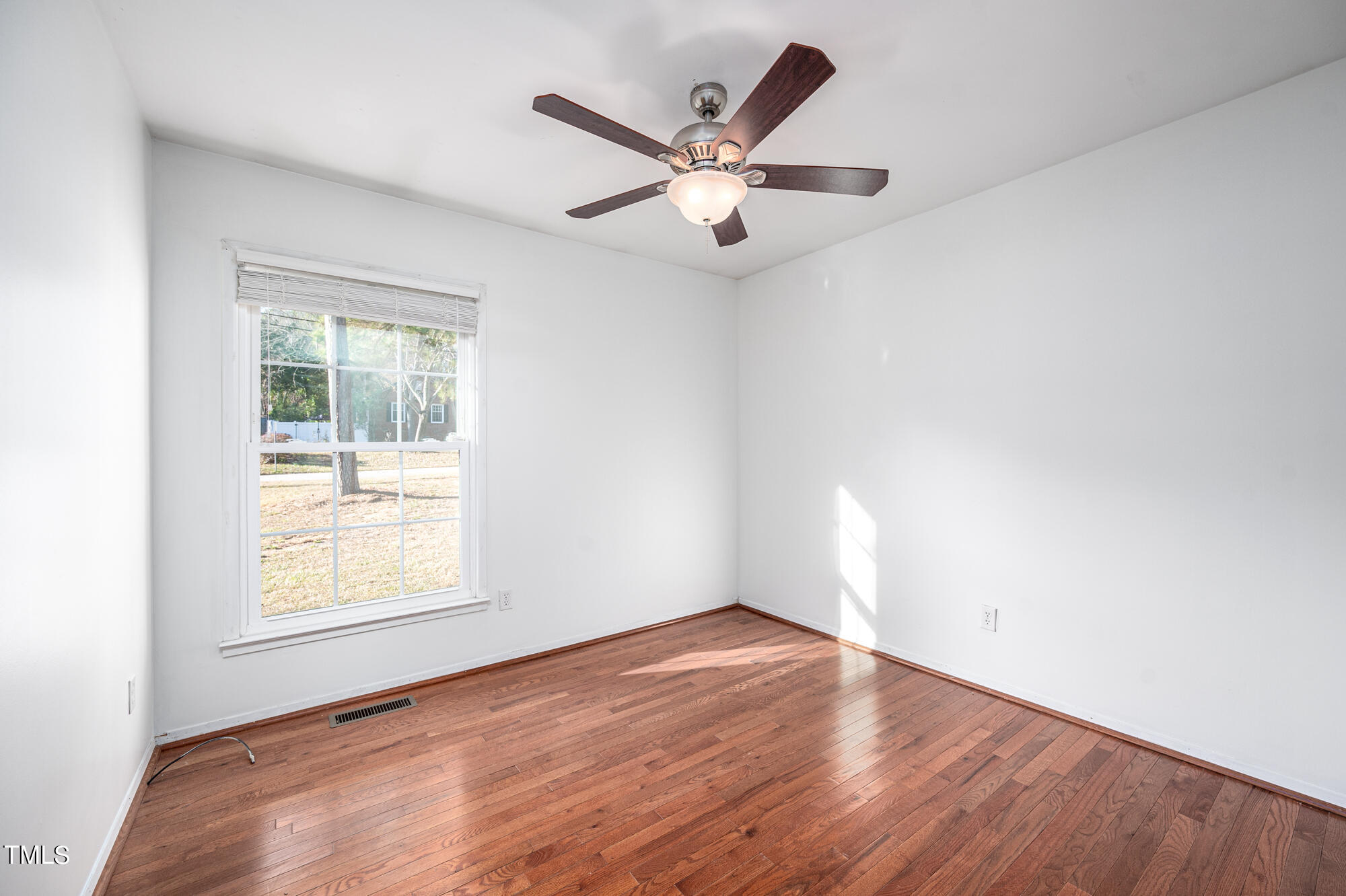 5215 Pelham Road Durham, NC 27713 - Photo 30 of 45 an empty room with wooden floor fan and windows