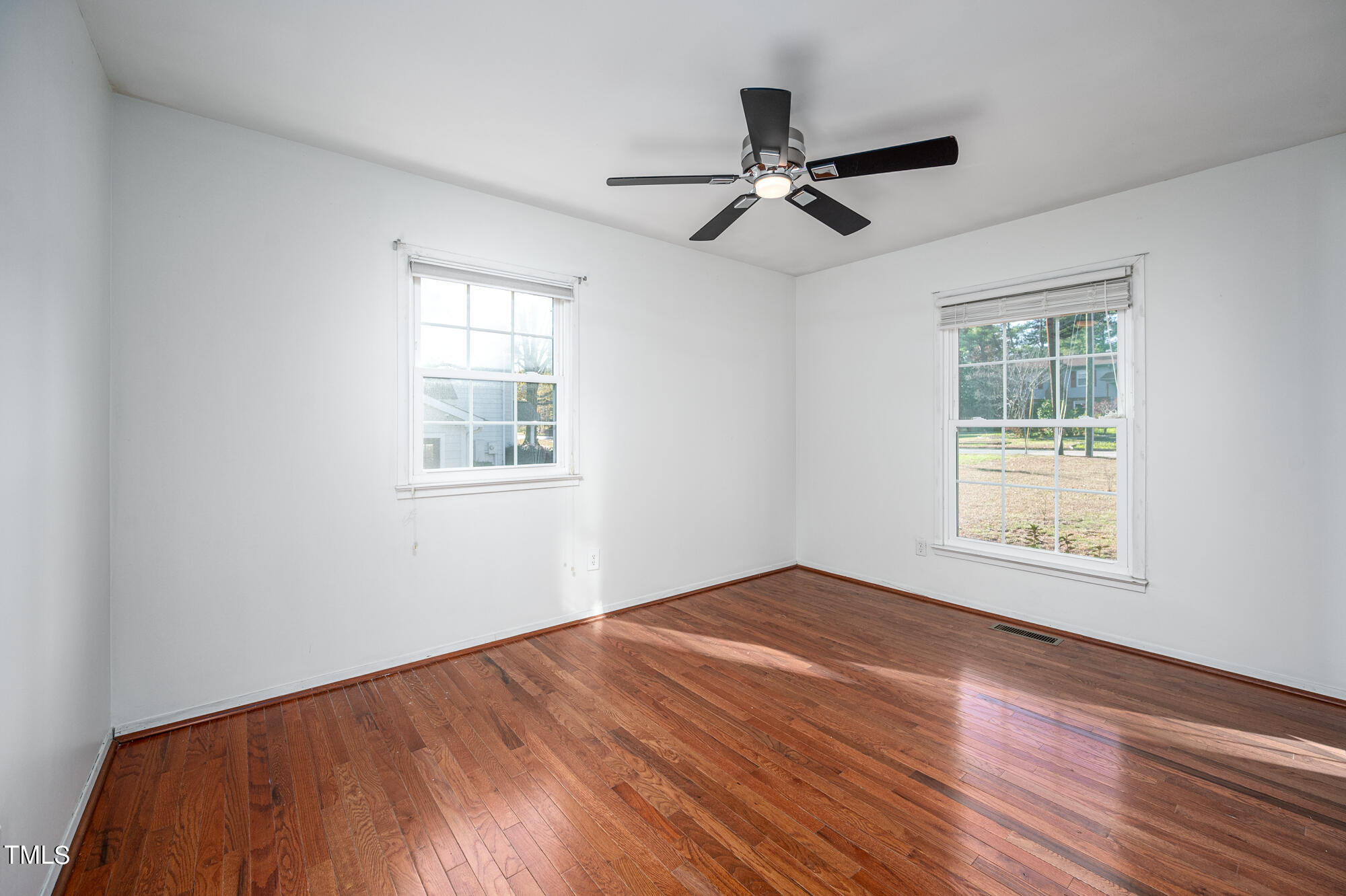 5215 Pelham Road Durham, NC 27713 - Photo 32 of 45 a view of an empty room with wooden floor and a window