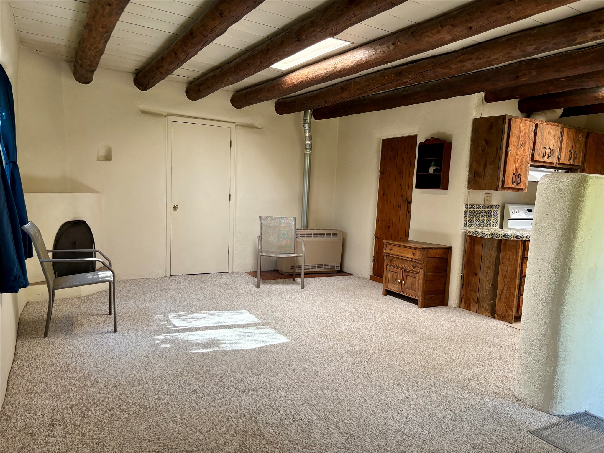 2175 Old Arroyo Chamiso Road, Unit 2 Santa Fe, NM 87505 - Photo 10 of 20 sitting area, kitchen, and door to bathroom (empty of furnishings)
