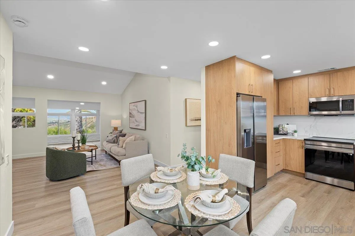 3615 Vista Bella, Unit 30 Oceanside, CA 92057 - Photo 12 of 38 a kitchen with stainless steel appliances kitchen island granite countertop a dining table chairs refrigerator and sink
