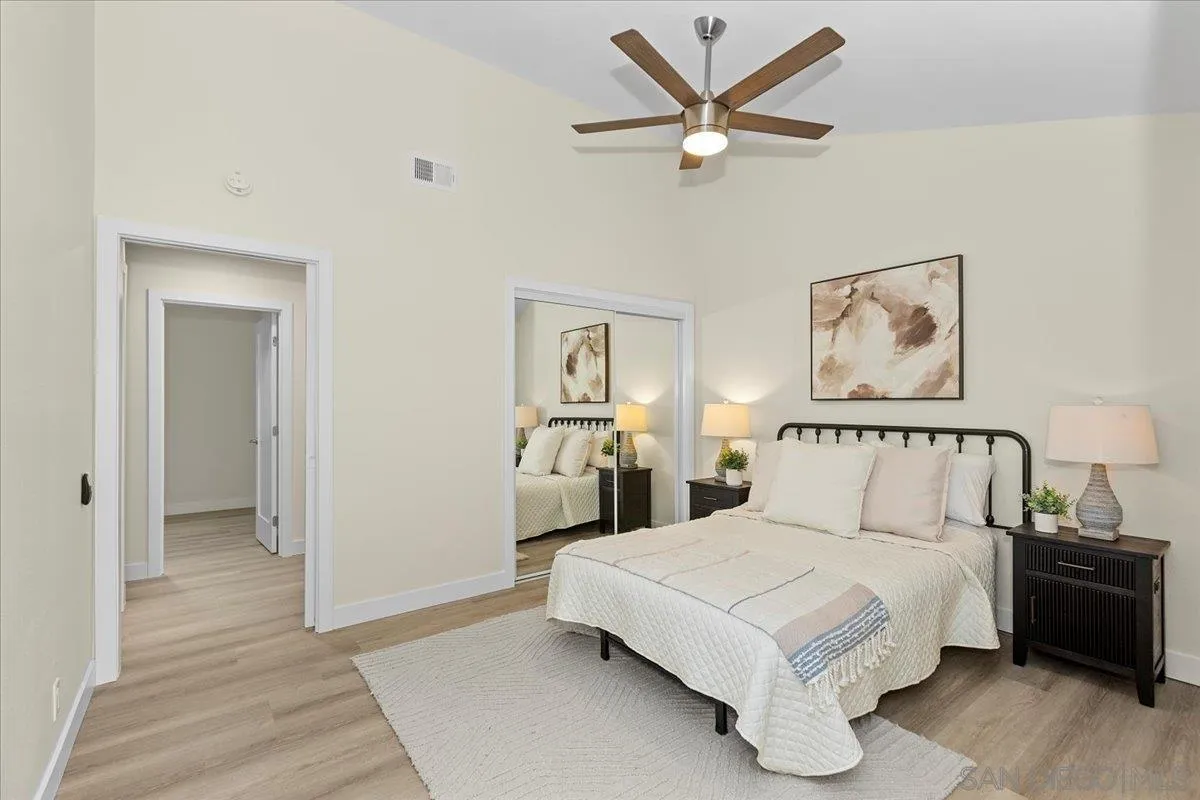3615 Vista Bella, Unit 30 Oceanside, CA 92057 - Photo 21 of 38 a bedroom with a large bed and a chandelier