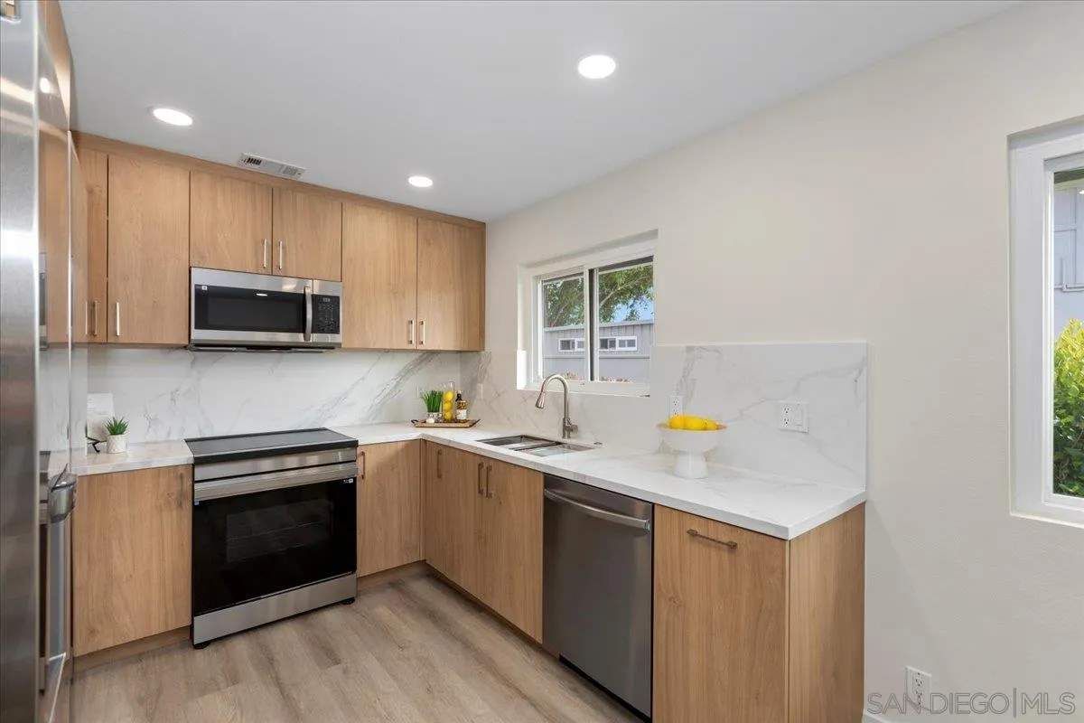3615 Vista Bella, Unit 30 Oceanside, CA 92057 - Photo 9 of 38 a kitchen with stainless steel appliances a stove sink microwave and cabinets