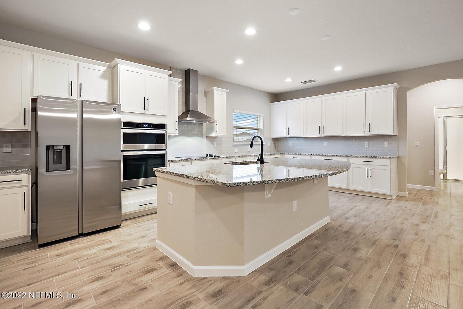 997 Silver Landing Drive, Unit 417 St. Augustine, FL 32092 - Photo 3 of 19 a kitchen with stainless steel appliances granite countertop a refrigerator a sink a stove a microwave and white cabinets with wooden floor