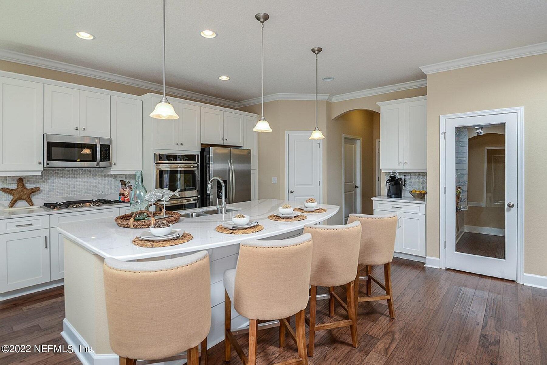 997 Silver Landing Drive, Unit 417 St. Augustine, FL 32092 - Photo 4 of 19 a kitchen with a dining table chairs stainless steel appliances and cabinets