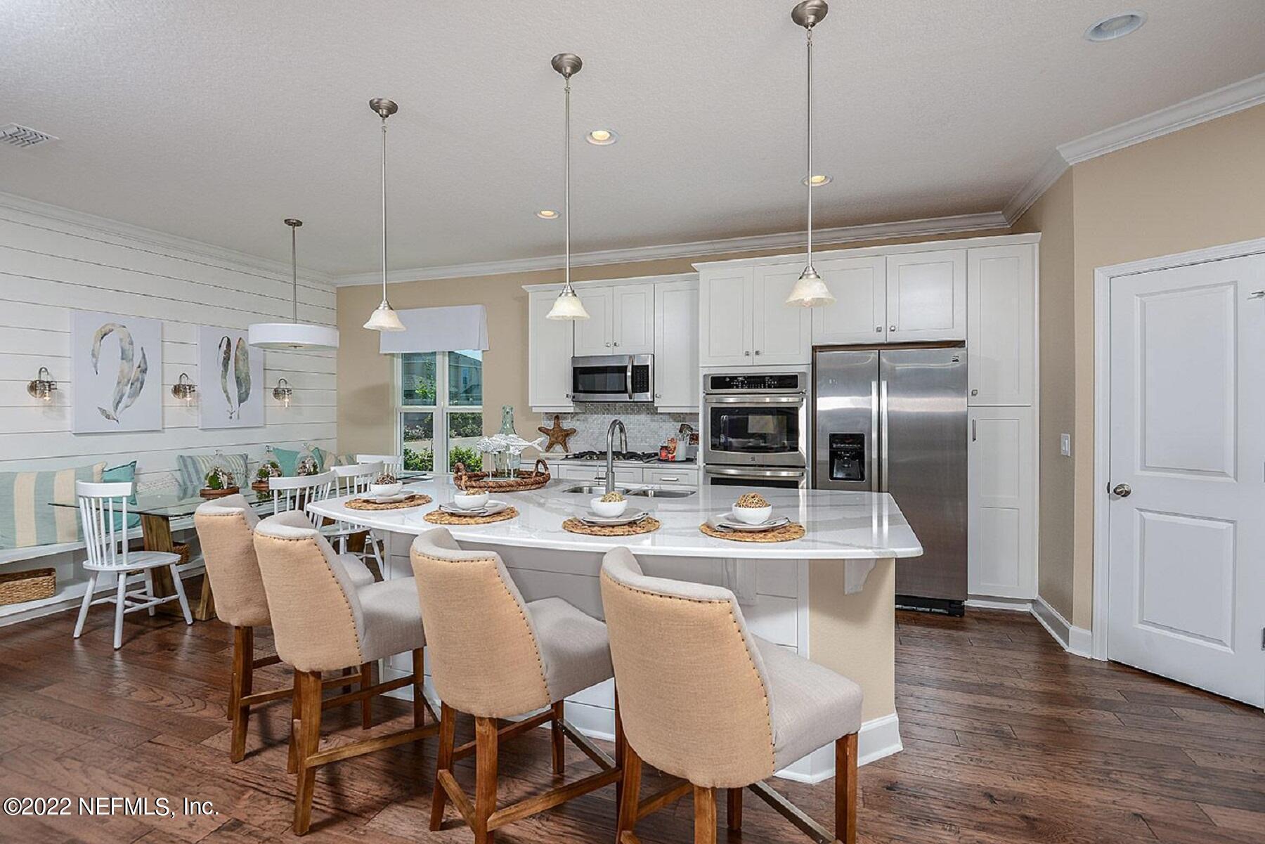 997 Silver Landing Drive, Unit 417 St. Augustine, FL 32092 - Photo 5 of 19 a dining room with stainless steel appliances kitchen island granite countertop a dining table chairs and a refrigerator