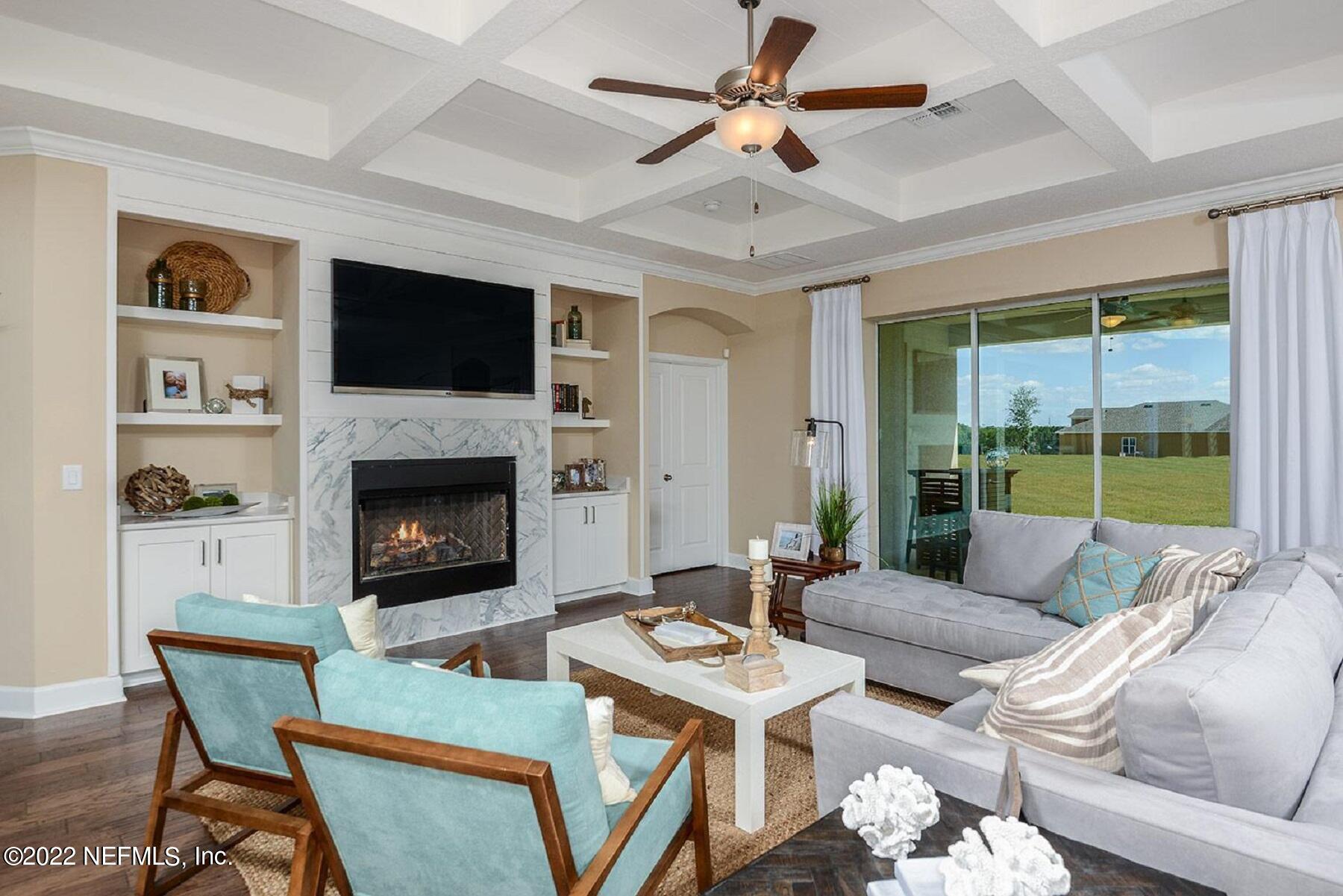 997 Silver Landing Drive, Unit 417 St. Augustine, FL 32092 - Photo 6 of 19 a living room with furniture a fireplace and a flat screen tv