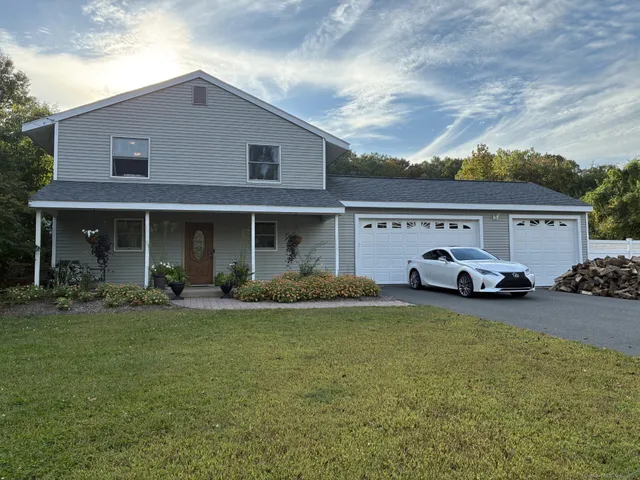 a view of a house with a patio and a yard