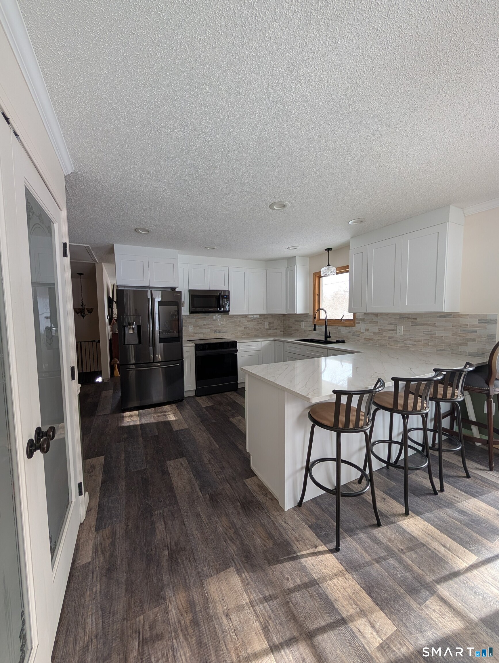 125 North Granby Road Granby, CT 06035 - Photo 12 of 25 a kitchen with stainless steel appliances granite countertop a stove top oven a sink a dining table and chairs