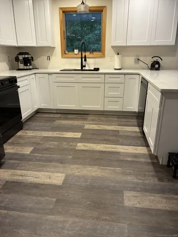 a white kitchen with sink and cabinets
