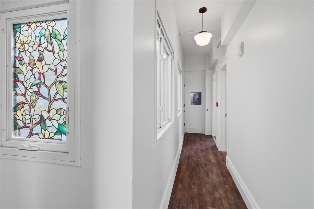 105 High Street, Unit 4P Holyoke, MA 01040 - Photo 6 of 11 a view of a hallway with wooden floor and a chandelier