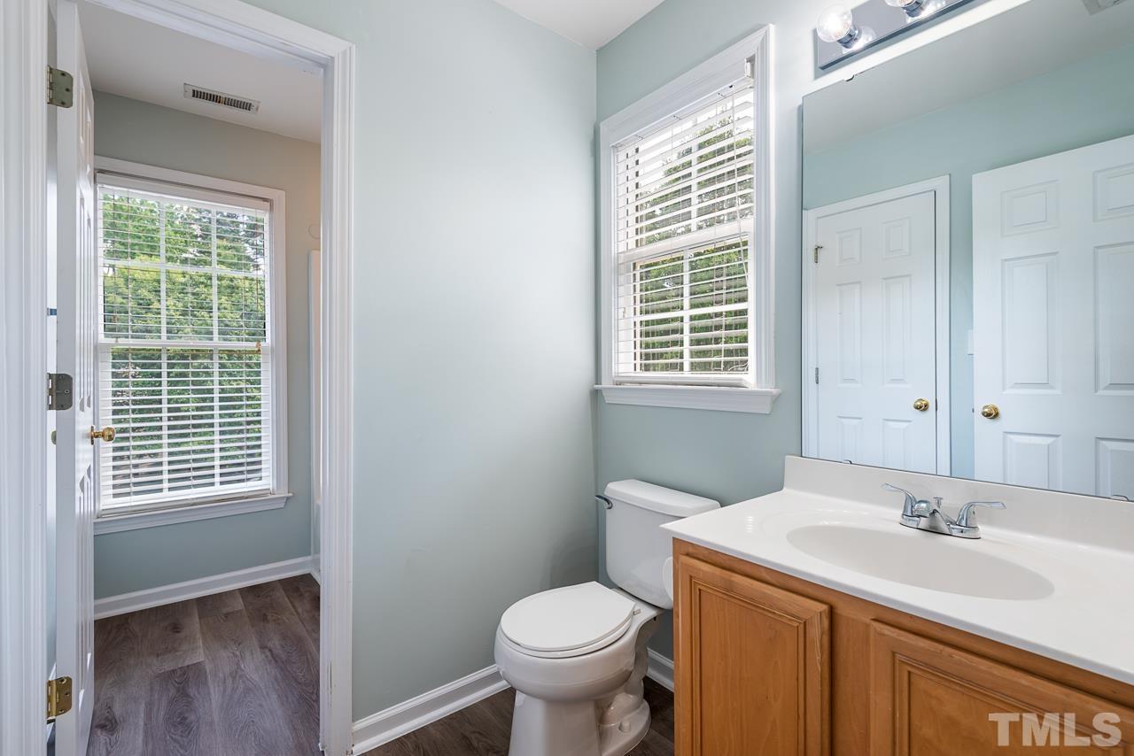 5626 Slide Rock Lane Raleigh, NC 27613 - Photo 36 of 46 a bathroom with a granite countertop toilet a sink and a window