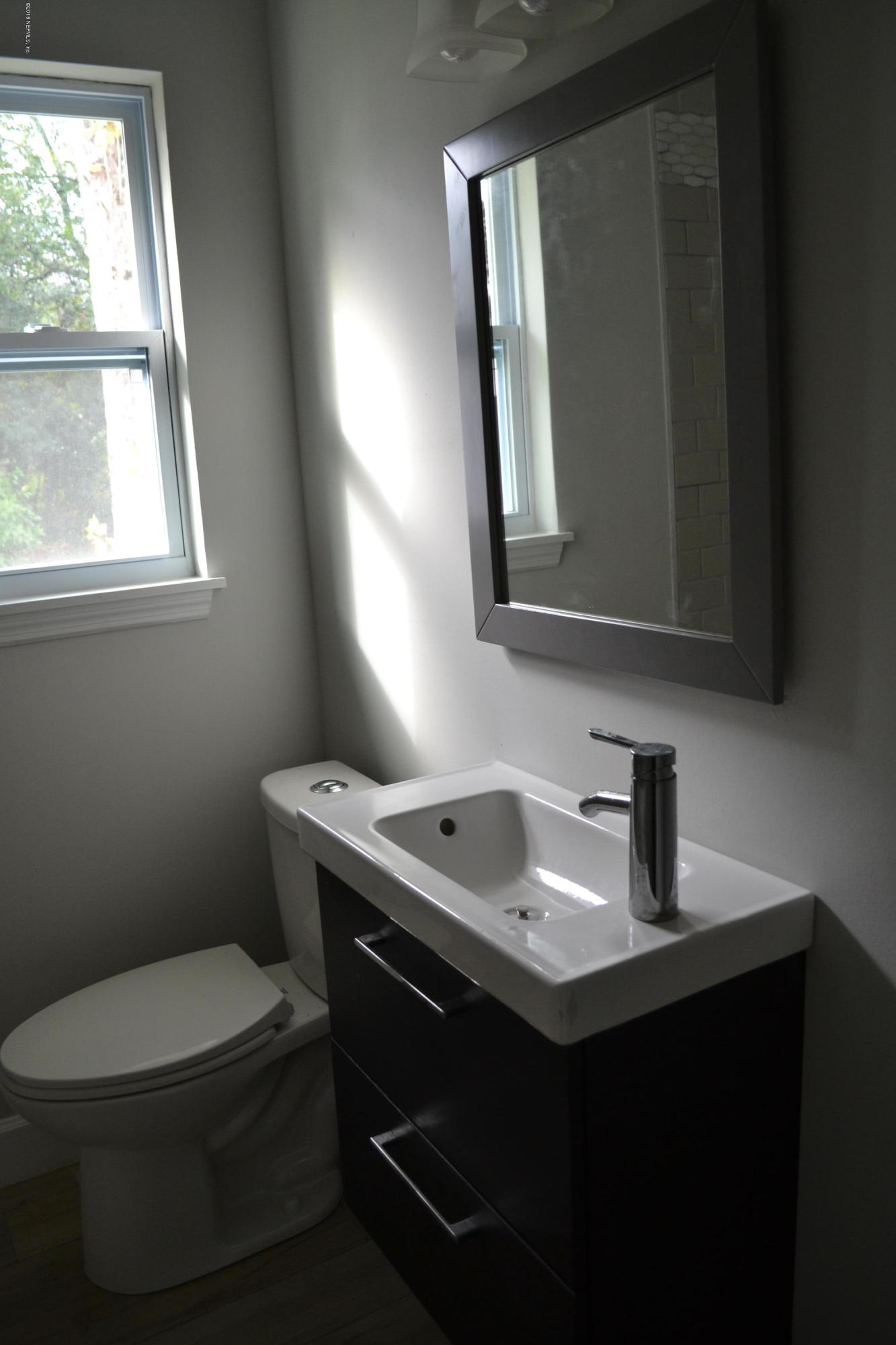 2726 Sam Road Jacksonville, FL 32216 - Photo 15 of 19 a bathroom with a toilet sink and mirror