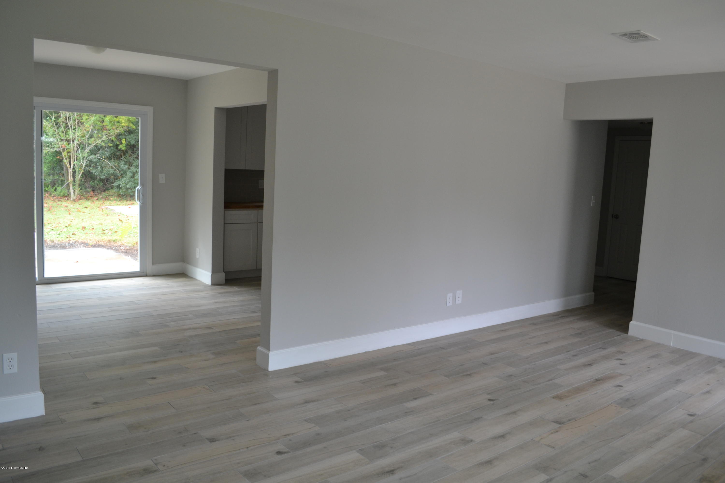 2726 Sam Road Jacksonville, FL 32216 - Photo 8 of 19 a view of an empty room with wooden floor and a window