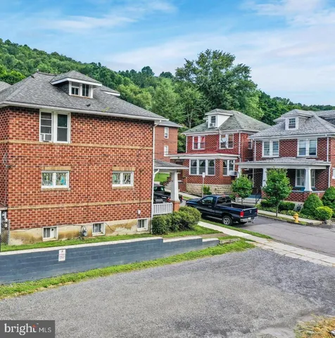 a front view of residential houses with yard and green space
