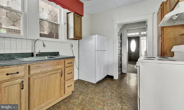a kitchen with white cabinets and refrigerator
