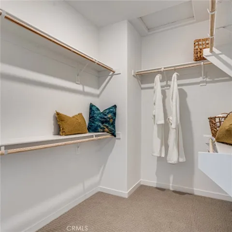 a view of walk in closet with clothes and shoes