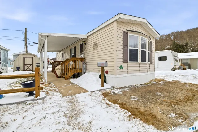 a view of a house with snow on the side of the road