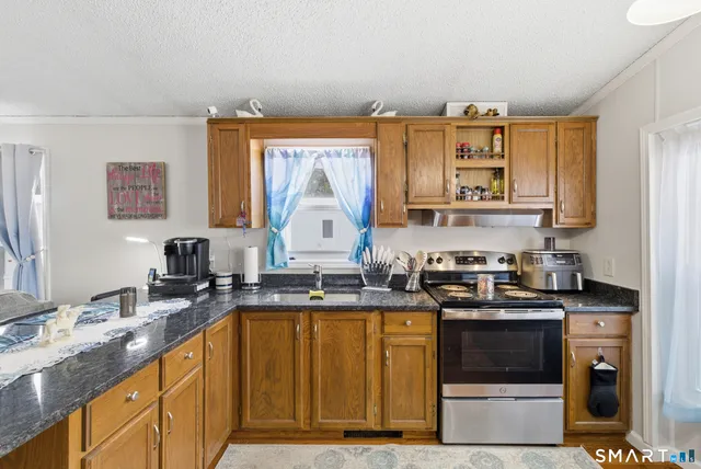 a kitchen with stainless steel appliances granite countertop a sink stove and cabinets